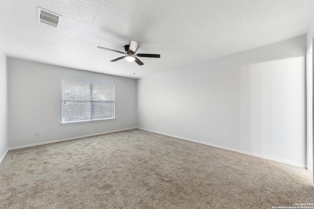 empty room with carpet flooring, ceiling fan, and a textured ceiling