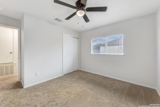 unfurnished bedroom with carpet, a closet, and ceiling fan