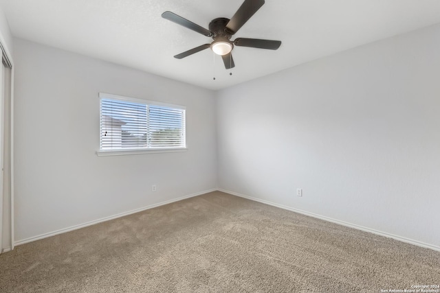 carpeted spare room with ceiling fan