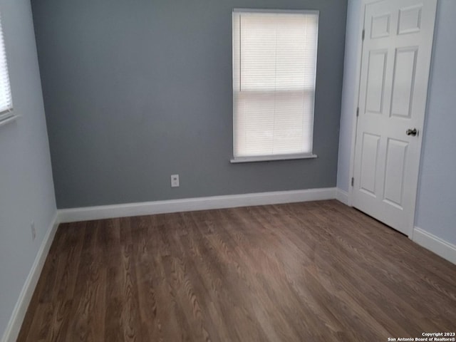 unfurnished room featuring dark wood-type flooring