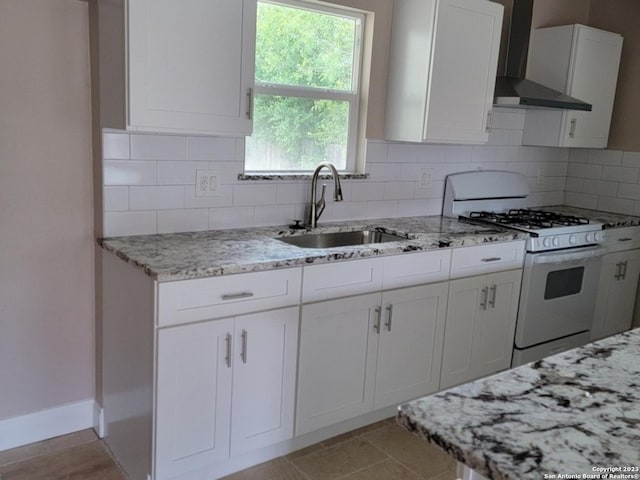 kitchen with white cabinets, wall chimney range hood, sink, decorative backsplash, and gas range gas stove