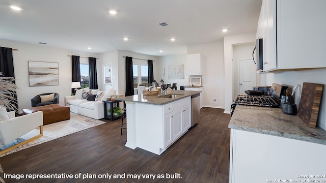 kitchen with light stone countertops, appliances with stainless steel finishes, dark hardwood / wood-style flooring, a center island with sink, and white cabinetry