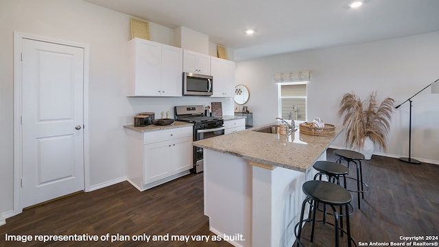 kitchen with white cabinetry, dark wood-type flooring, stainless steel appliances, and an island with sink