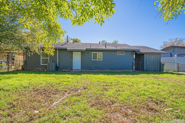 back of property featuring a lawn and central AC