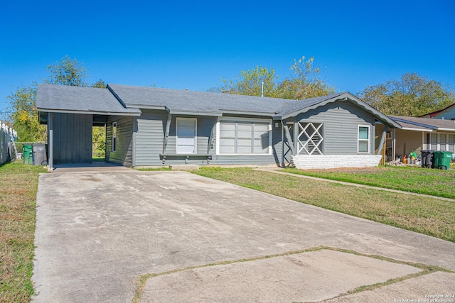 ranch-style house featuring a front lawn and a carport