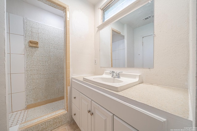 bathroom featuring a tile shower and vanity