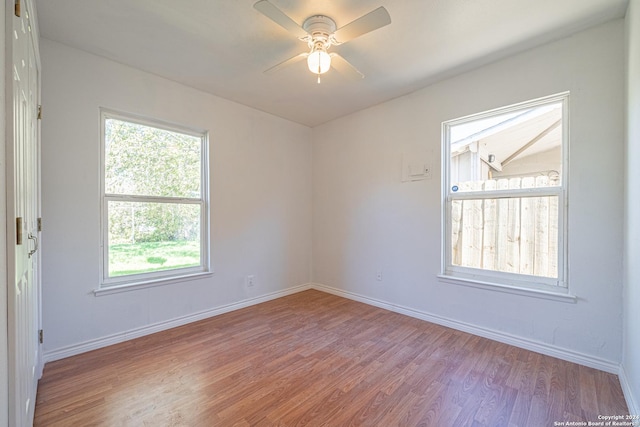 empty room with ceiling fan and light hardwood / wood-style floors