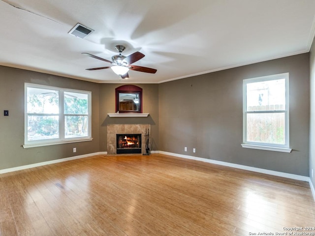 unfurnished living room with ceiling fan, light wood-type flooring, and ornamental molding