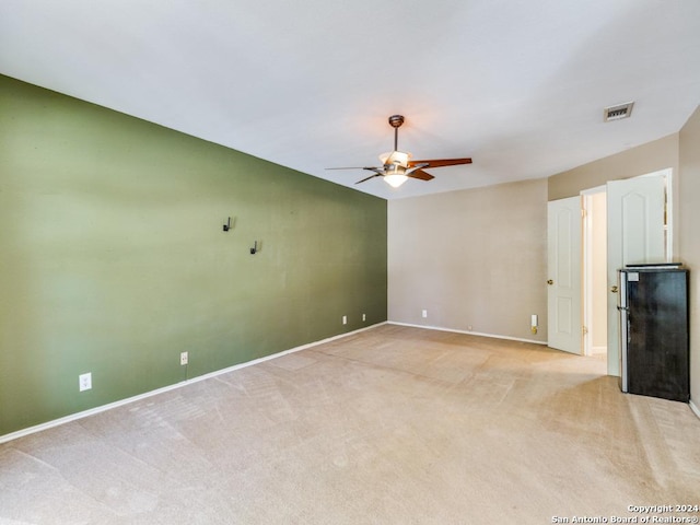 unfurnished living room featuring ceiling fan and light colored carpet