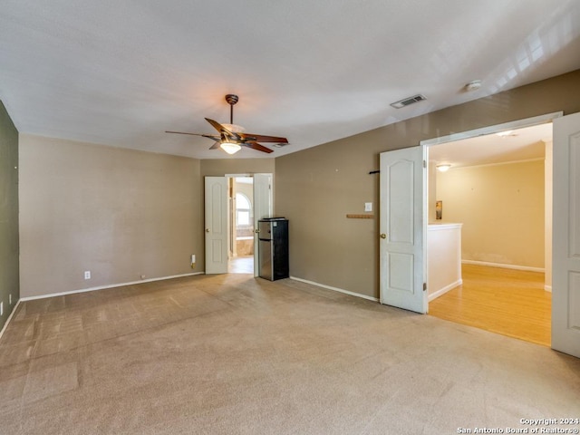 unfurnished living room featuring ceiling fan and light colored carpet