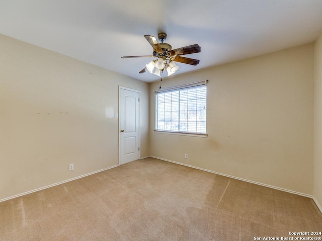 carpeted spare room featuring ceiling fan