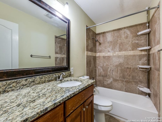 full bathroom featuring tile patterned flooring, vanity, tiled shower / bath combo, and toilet