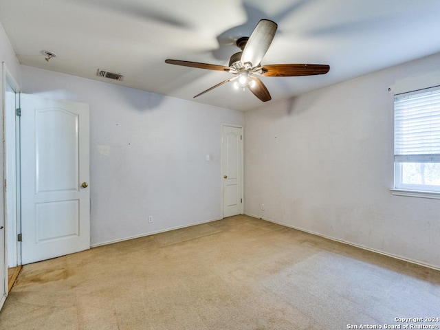 carpeted spare room with ceiling fan