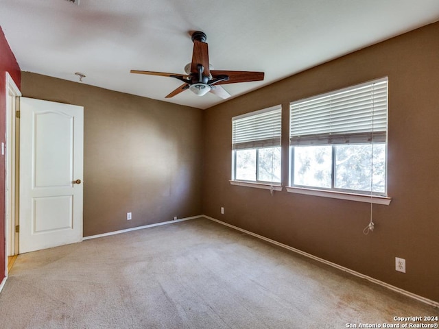 carpeted spare room featuring ceiling fan