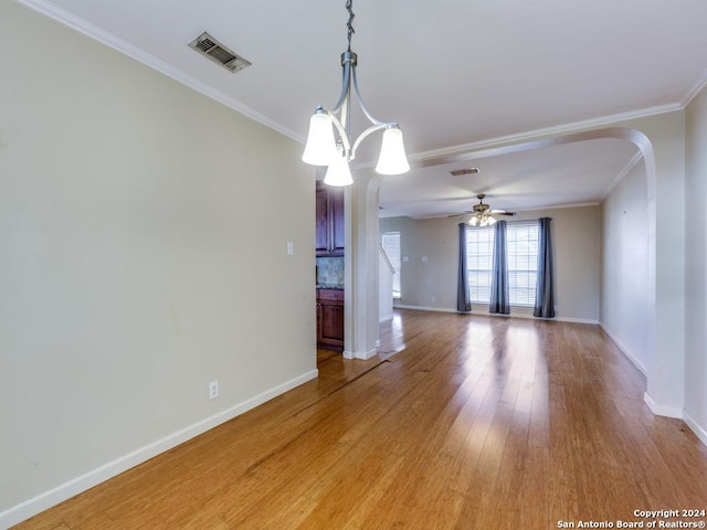 spare room featuring light hardwood / wood-style floors, ceiling fan with notable chandelier, and ornamental molding