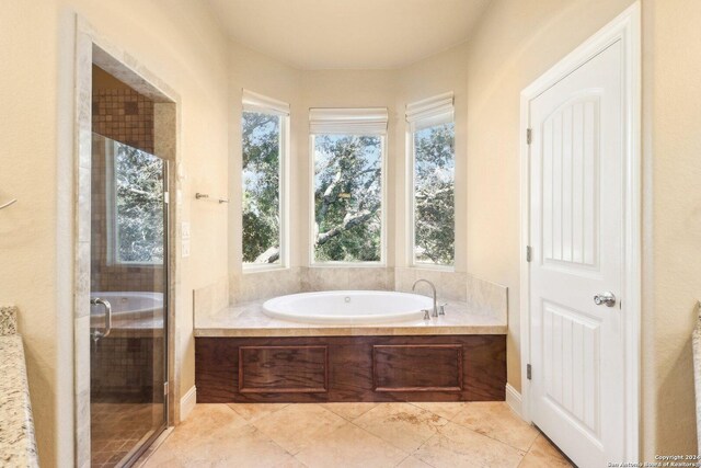 bathroom featuring a wealth of natural light and shower with separate bathtub