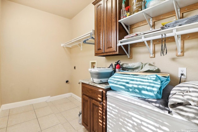 laundry room with hookup for an electric dryer, light tile patterned flooring, cabinets, and hookup for a washing machine