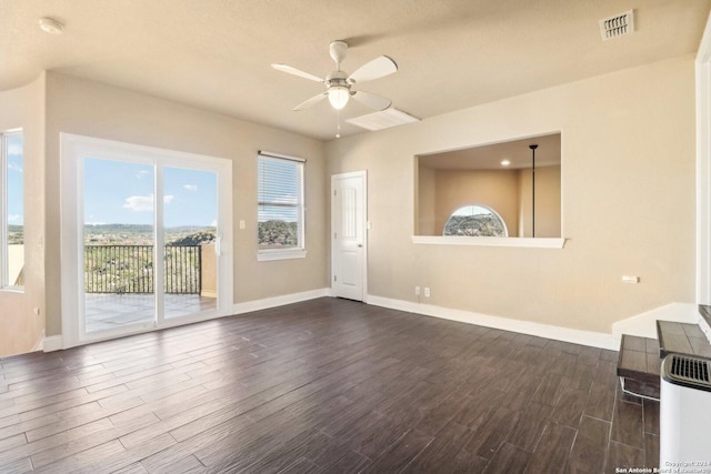 unfurnished living room featuring a textured ceiling, ceiling fan, and dark hardwood / wood-style floors