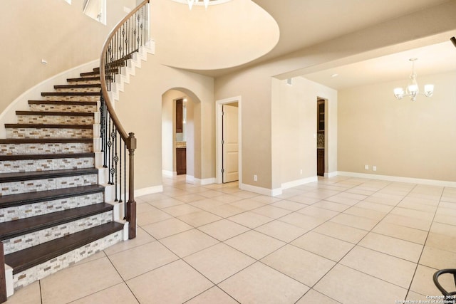 stairway featuring tile patterned floors and a notable chandelier