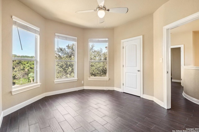11224 Cave Crk, Helotes, TX 78023 - unfurnished bedroom featuring dark wood-style floors, multiple windows, and a ceiling fan