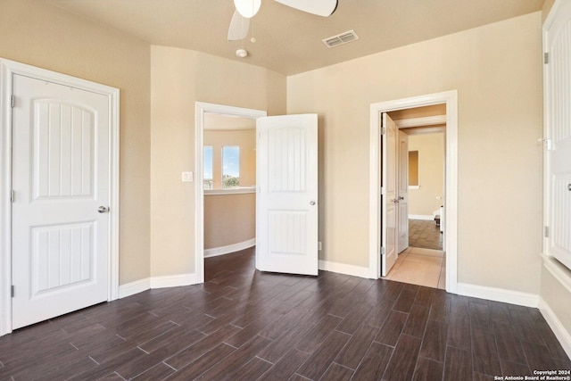 unfurnished bedroom featuring ceiling fan and dark wood-type flooring