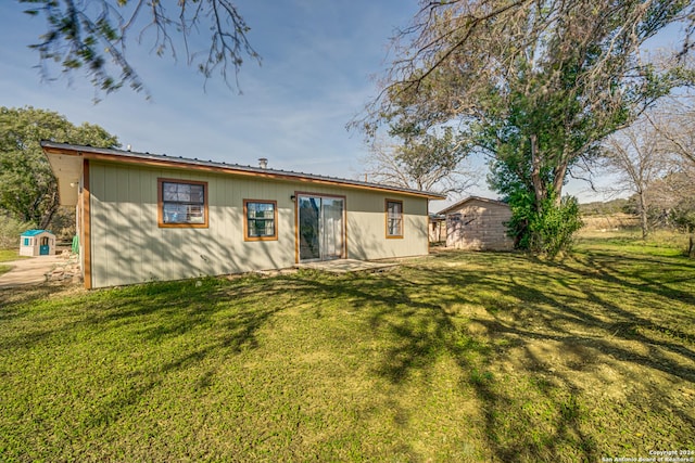 rear view of house featuring a yard