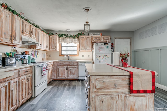 kitchen with sink, dark hardwood / wood-style floors, pendant lighting, white appliances, and a kitchen island