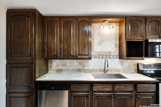 kitchen featuring appliances with stainless steel finishes, backsplash, dark brown cabinets, and sink