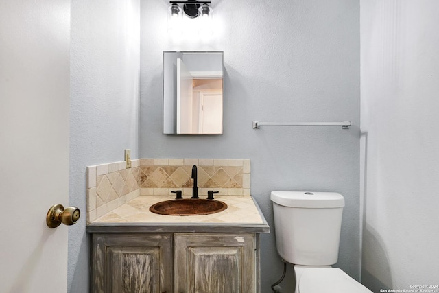 bathroom with decorative backsplash, vanity, and toilet