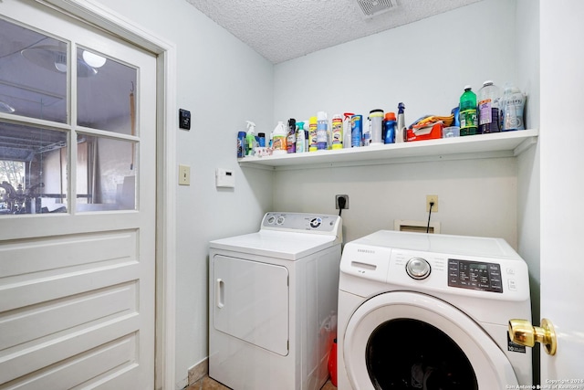 clothes washing area featuring a textured ceiling and washing machine and clothes dryer