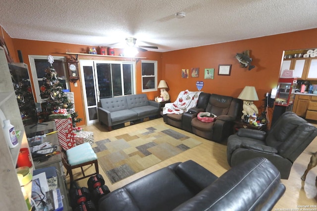 living room featuring ceiling fan and a textured ceiling