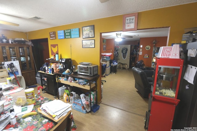 office featuring hardwood / wood-style floors, a textured ceiling, and ceiling fan