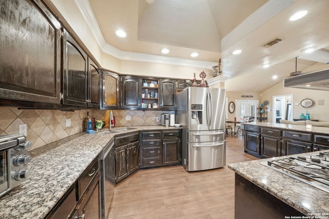 kitchen featuring decorative backsplash, appliances with stainless steel finishes, dark brown cabinetry, sink, and lofted ceiling