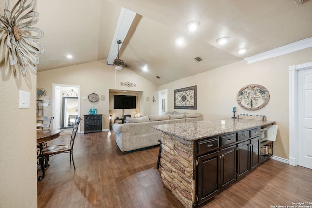 kitchen featuring a kitchen bar, vaulted ceiling with beams, dark hardwood / wood-style flooring, and dark brown cabinets