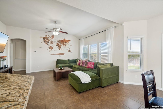 living room featuring dark tile patterned flooring, plenty of natural light, and vaulted ceiling