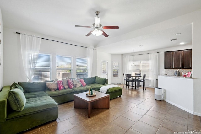 living room with ceiling fan, light tile patterned flooring, and a wealth of natural light