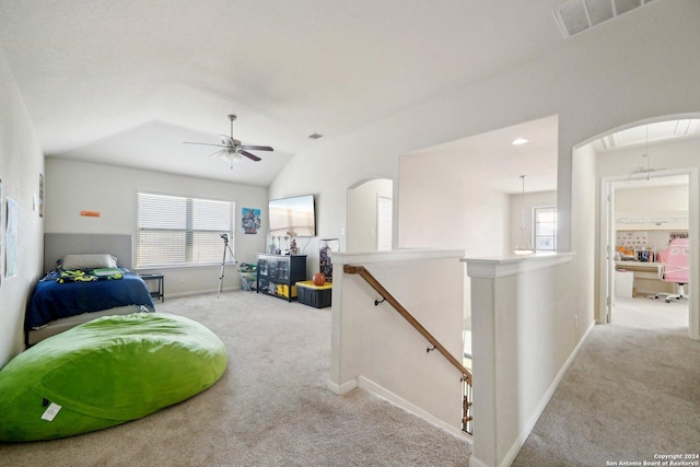 interior space featuring ceiling fan, light colored carpet, and vaulted ceiling