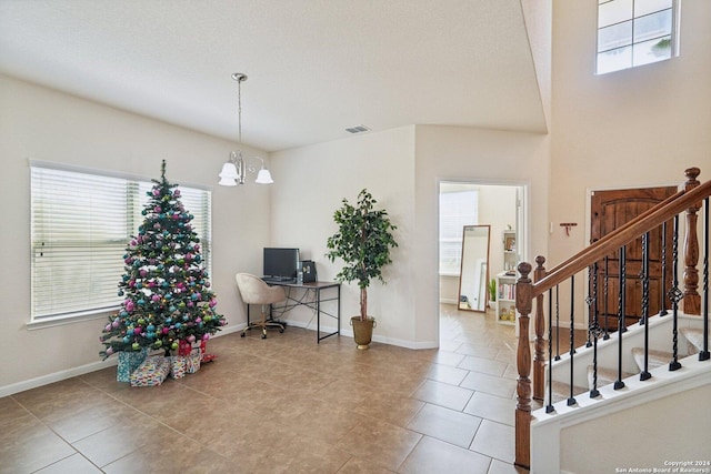 tiled foyer entrance with a notable chandelier and a textured ceiling