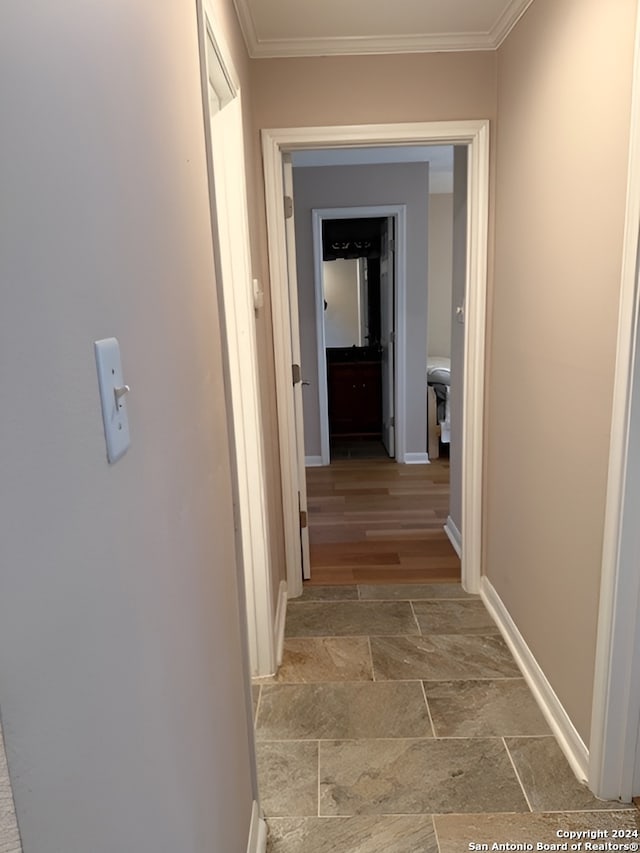 hallway with light hardwood / wood-style floors and ornamental molding