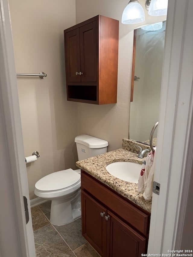 bathroom featuring tile patterned flooring, vanity, and toilet