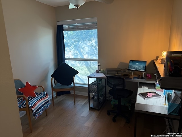 home office featuring ceiling fan, wood-type flooring, and a wealth of natural light