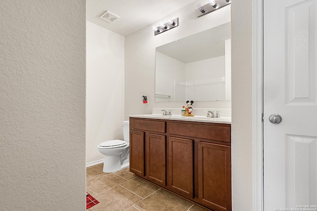 bathroom featuring toilet, vanity, and tile patterned floors