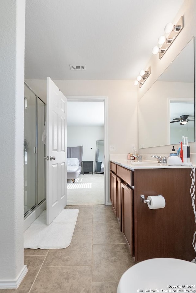 bathroom featuring tile patterned flooring, vanity, ceiling fan, and an enclosed shower