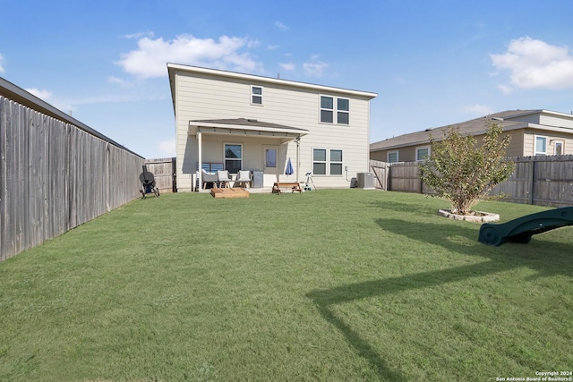 back of house featuring a yard, central AC unit, and a patio area