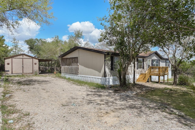 view of property exterior with a carport, a deck, and a storage unit