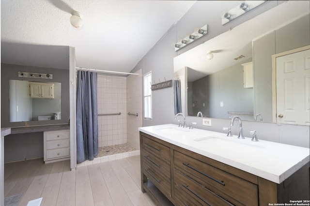 bathroom with walk in shower, a textured ceiling, vanity, hardwood / wood-style floors, and lofted ceiling