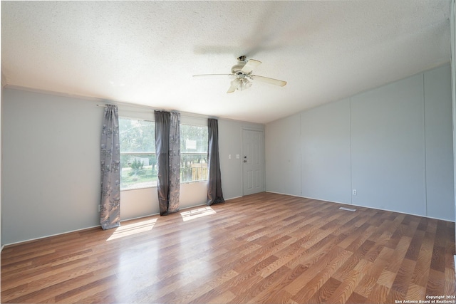 empty room featuring ceiling fan, wood-type flooring, and a textured ceiling