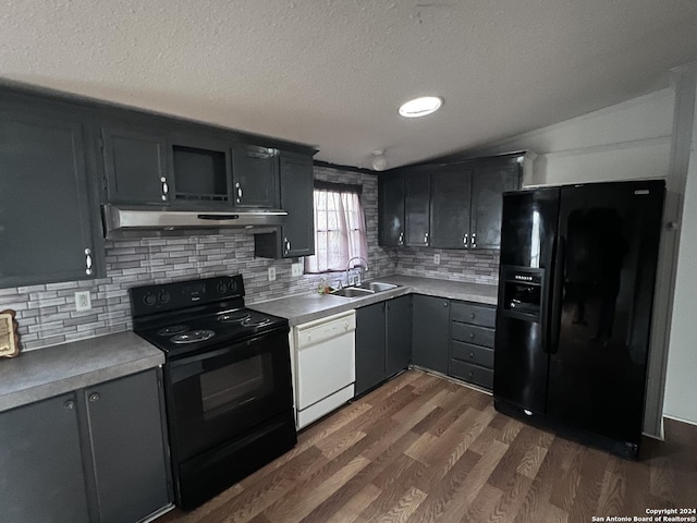 kitchen featuring sink, dark hardwood / wood-style floors, backsplash, lofted ceiling, and black appliances