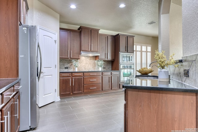 kitchen featuring appliances with stainless steel finishes, tasteful backsplash, and sink