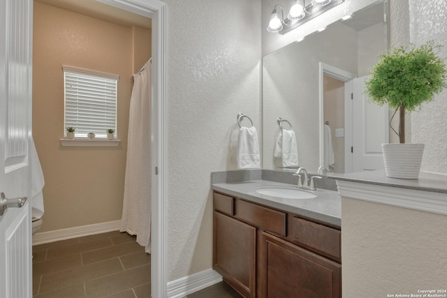 bathroom featuring tile patterned flooring, vanity, and toilet